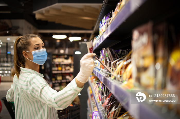 Woman protecting herself against corona virus or COVID-19 while shopping in supermarket. People wear