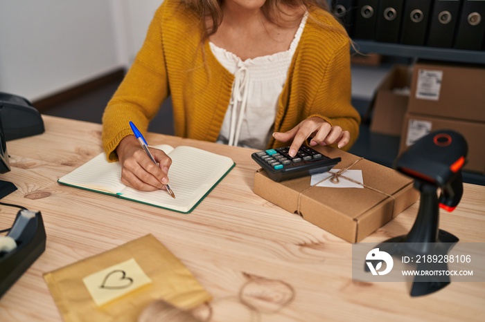 Young blonde woman ecommerce business worker writing on book at office