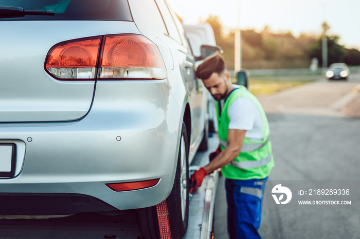 Handsome middle age man working in towing service on the road. Roadside assistance concept.