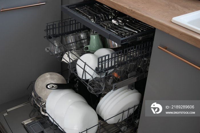 洗碗机与洗过的盘子特写，易于使用且节水，环保，内置厨房d