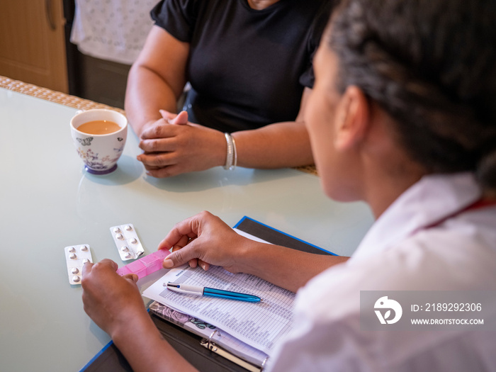 Nurse�visiting mature woman at her house, holding pill box