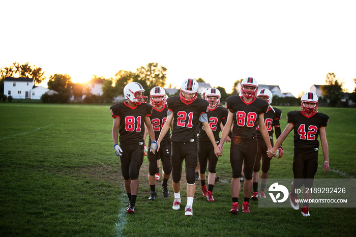 American football players walking in field