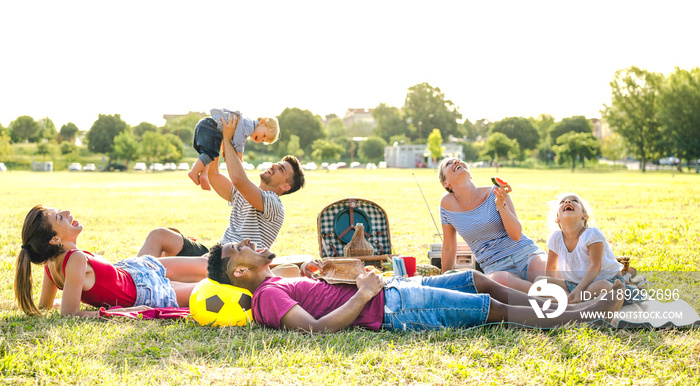 年轻的多种族家庭在野餐花园派对上与孩子们一起玩得很开心——多民族的欢乐