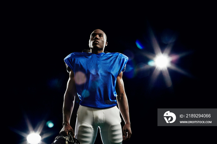 American football player holding helmet