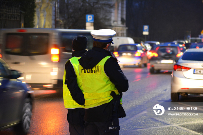 Policjanci ruchu drogowego polskiej policji w mieście podczas kontroli ruchu pojazdów.