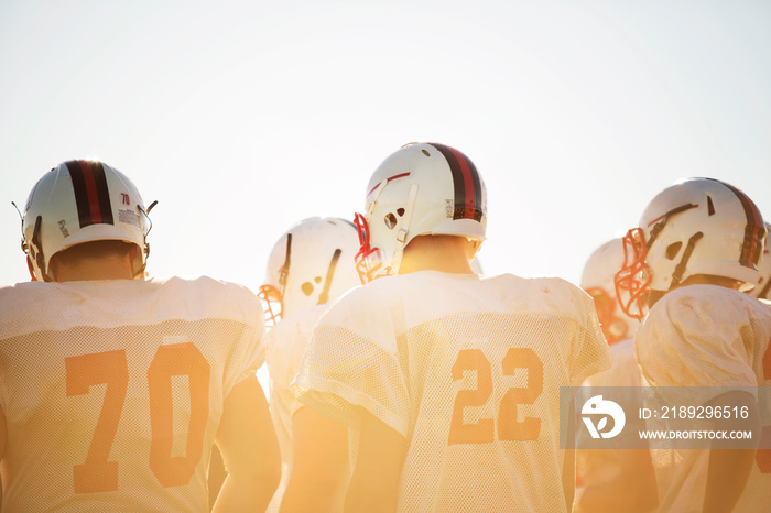 Teenage football players (14-15, 16-17) huddling around altogether