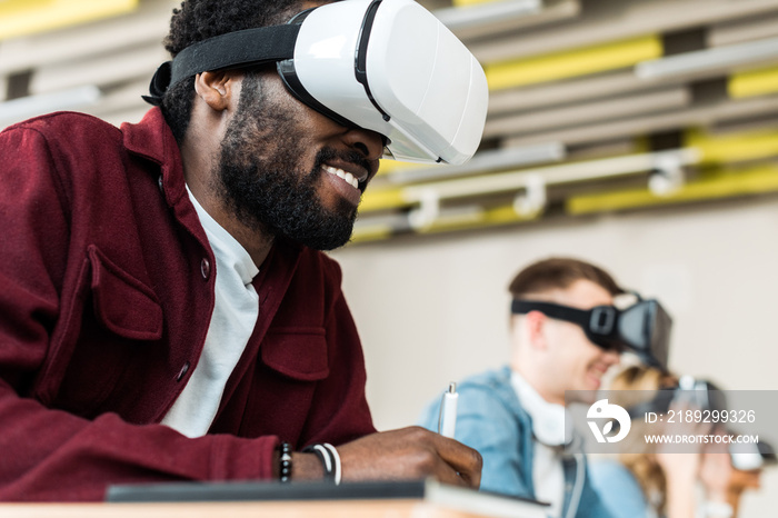 selective focus of smiling multicultural students using vr headsets