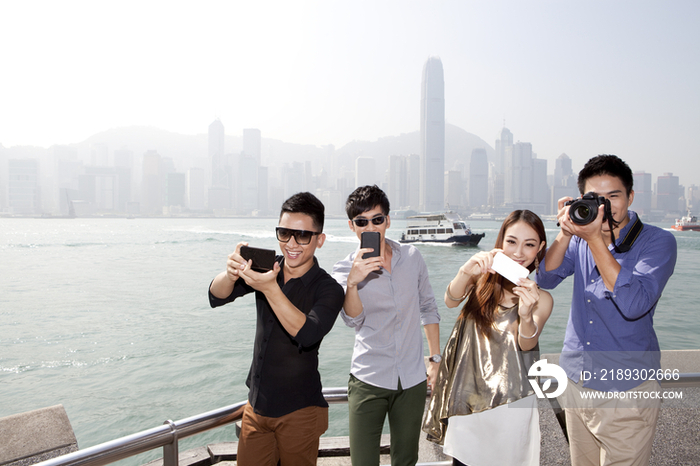 年轻朋友用智能手机和单反相机在香港拍照