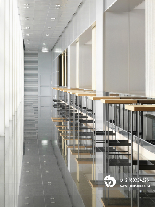 Short wooden tables in row along narrow hallway in the hotel