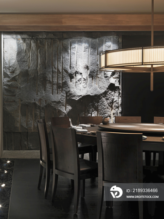 Circular wooden dining table below light fixture in restaurant