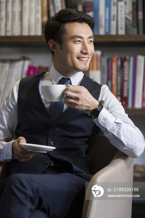年轻商务男子在书房喝咖啡