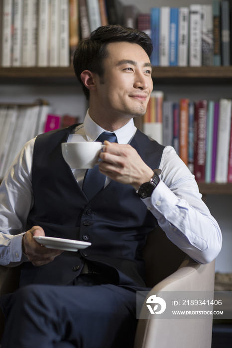 年轻商务男子在书房喝咖啡