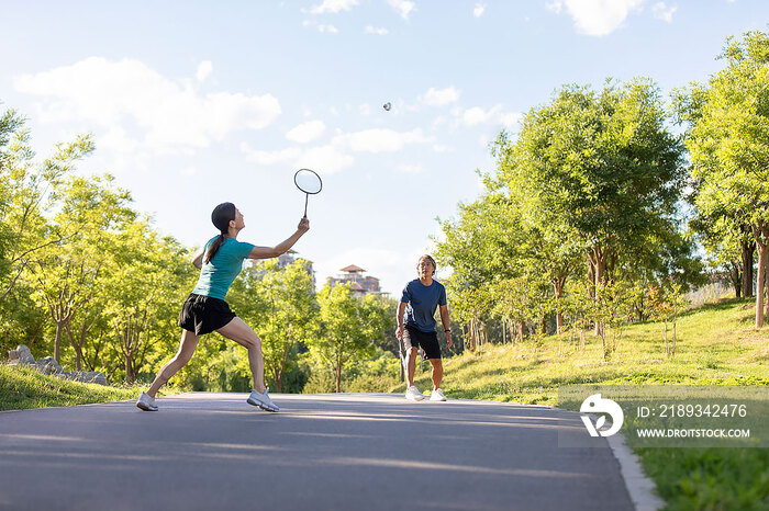 开心的中老年夫妇在户外打羽毛球