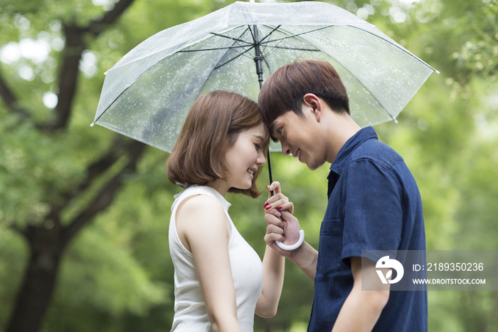 年轻情侣打着雨伞