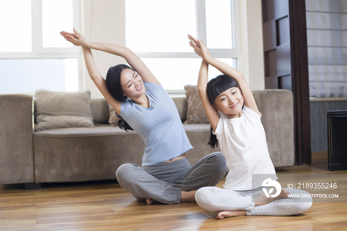年轻母女在家练瑜伽