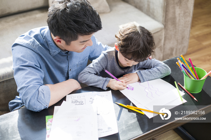 年轻父亲指导儿子做作业