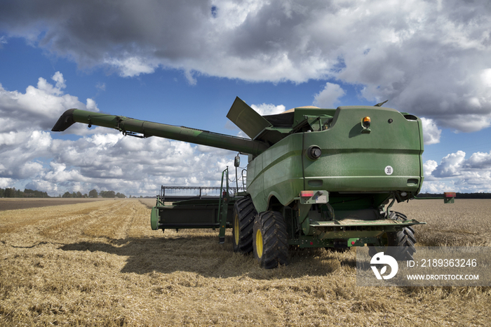 A large combine harvester machinery cutting the ripe arable crop