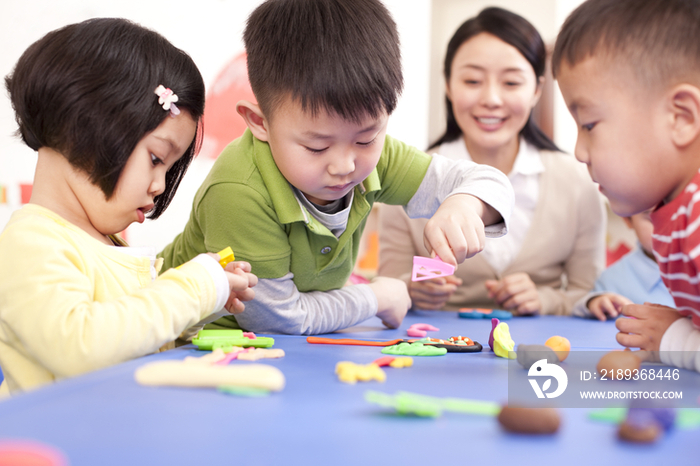 幼儿园老师教孩子们捏橡皮泥