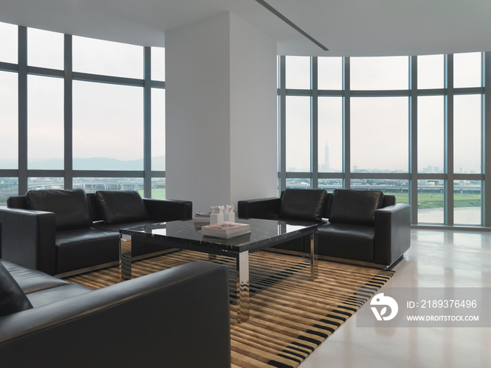 Black sofas in spacious lobby of modern office