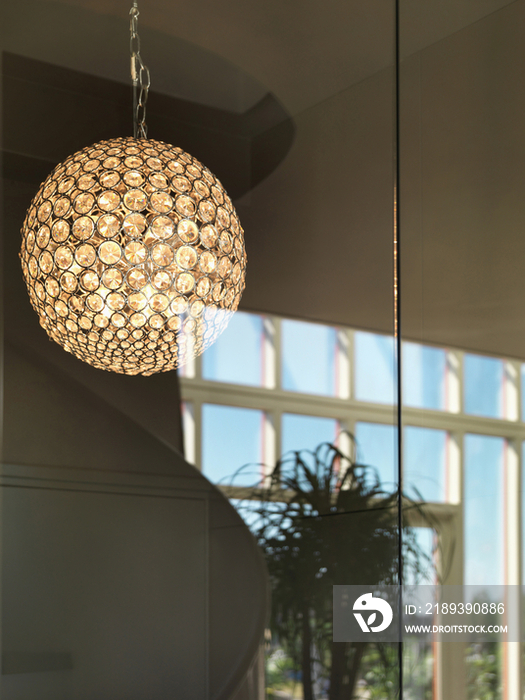 Detail shot of a lit round hanging light against blurred background