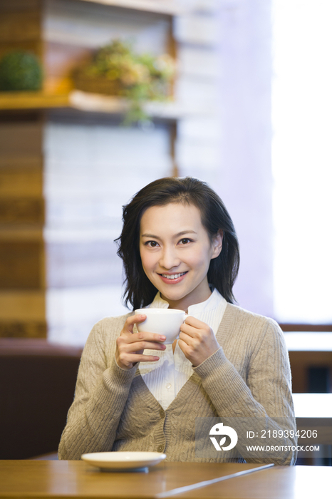 年轻女子在咖啡馆喝咖啡