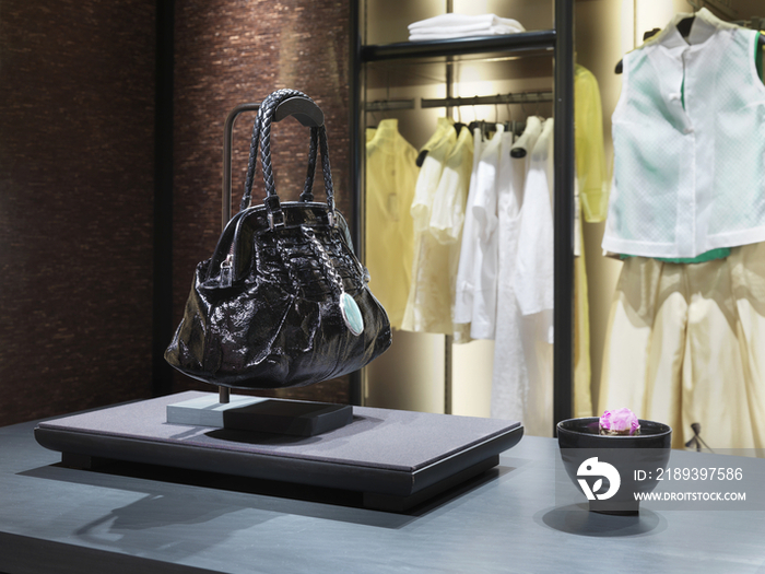 Black purse on display in clothing store