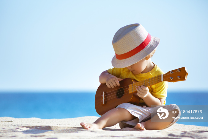 小男孩在海边弹吉他