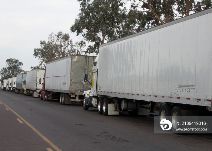 牵引车、拖车、卡车，沿路排成一排，等待运送货物