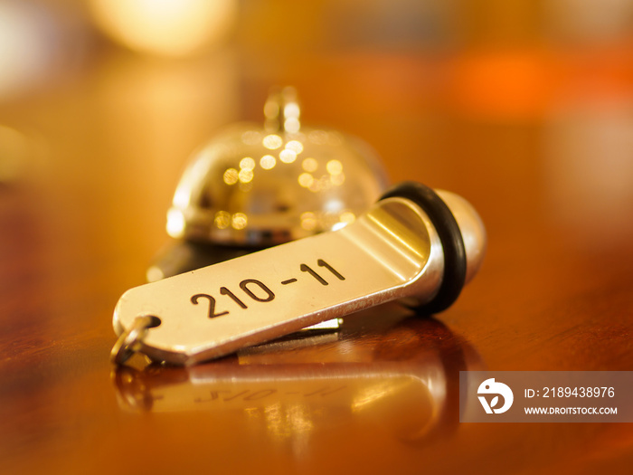 Hotel bell and key lying on the counter at the hotel reception in the lobby