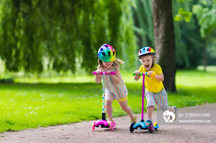 Little kids riding colorful scooters