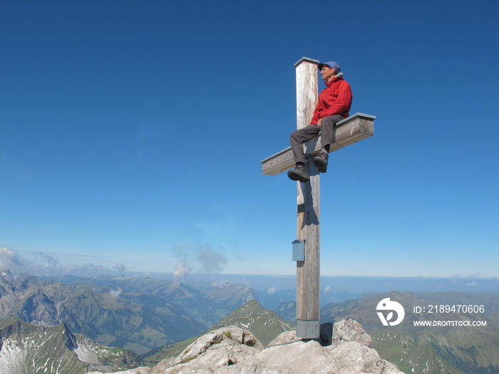 Bergsteiger am Gipfel mit Akrobatik auf Kreuz