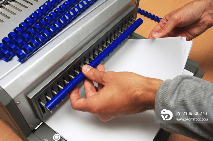 Binding machine with man who works on it.