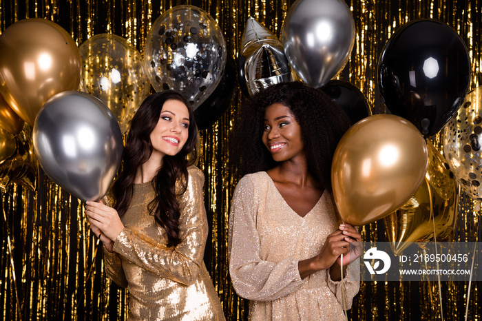 Photo of two beautiful young ladies hold balloons smile wear sequins dress isolated on shine glitter
