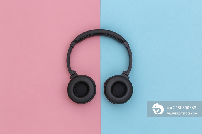 Wireless stereo headphones on pink blue background. Top view