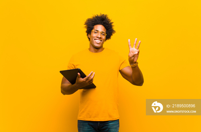 young african american man with a tablet against orange backgrou