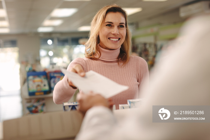 Customer giving a prescription to the chemist