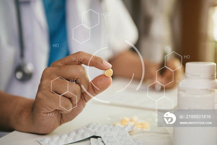 Pharmacist writes on a clipboard and holds pills in a pharmacy.