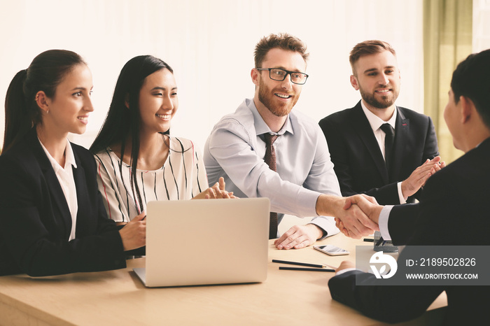 Human resources manager shaking hands with applicant after successful interview