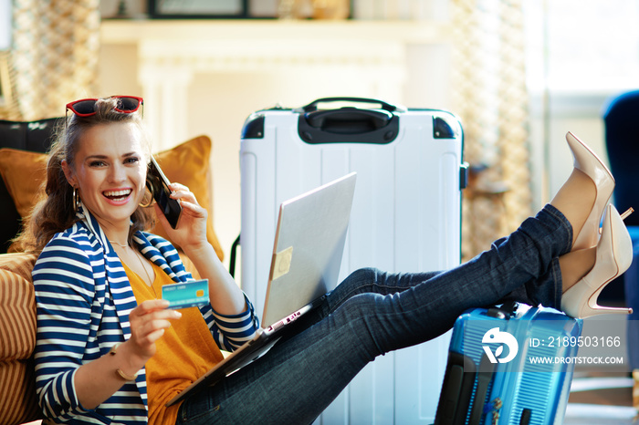 woman with credit card talking on phone to buy airplane tickets