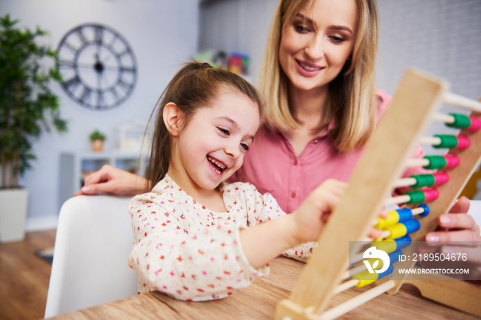 Girl and teacher using an abacus during homeschooling