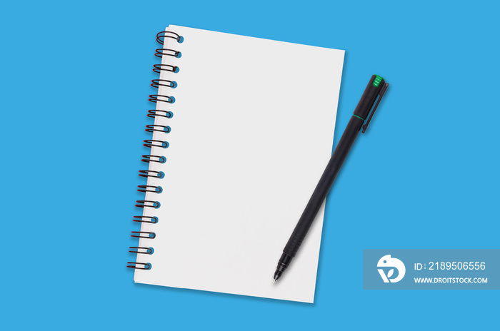 One paper notepad with spiral binder and blank sheets near black plastic pen lies of blue office tab