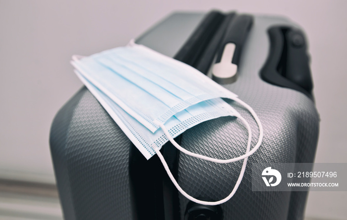行李箱上的医用口罩是后新冠肺炎时代旅行的必备品