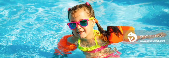 The little girl in the water park swimming underwater and smiling