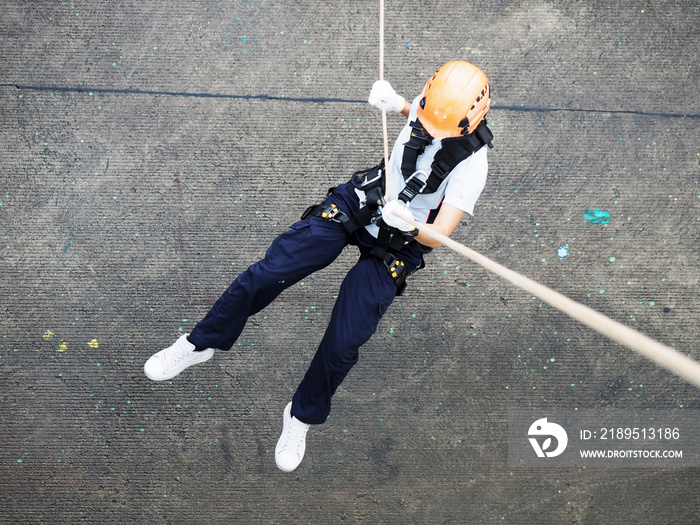 Firefighters are rappelling and climbing ropes at a drill exercise