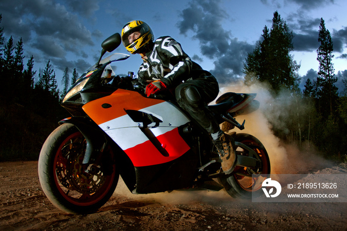 Man riding motorbike against sky at dusk