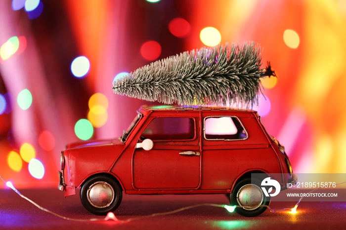 带圣诞树的圣诞车。红色玩具车，彩色桶上有装饰性的圣诞树