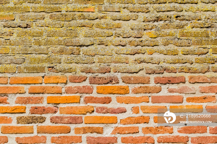 mur de briques anciennes, décapées en bas, non rénovées au-dessus