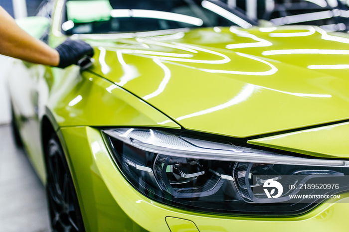 A man cleaning car, car detailing (or valeting) concept. Selective focus.