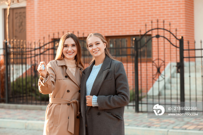 年轻的女同性恋夫妇在新房附近带着钥匙