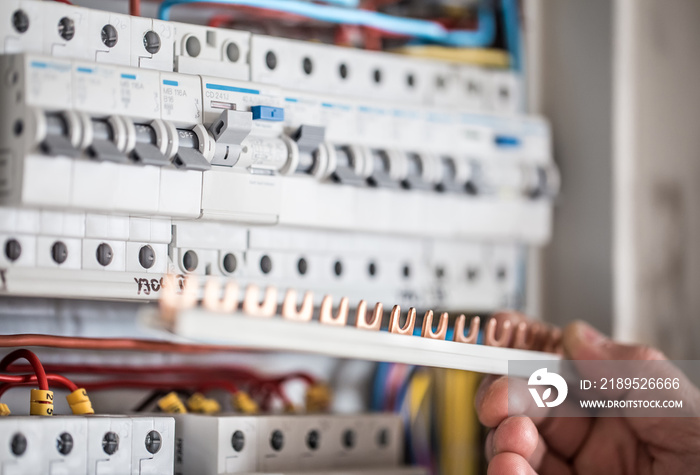 Man, an electrical technician working in a switchboard with fuses. Installation and connection of el